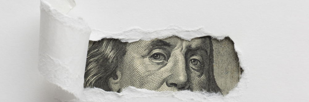 Moneda estadounidense detrás de papel blanco roto